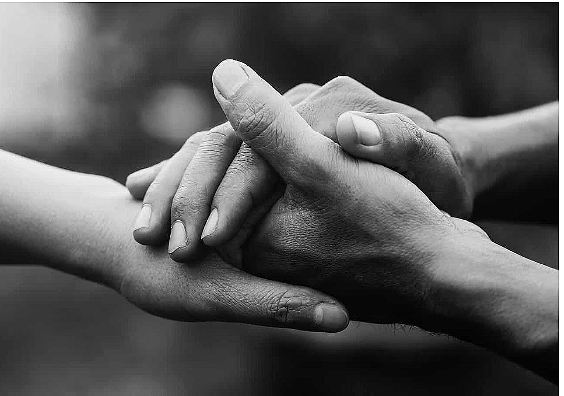 One hand holding another